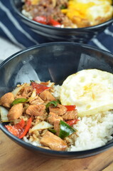 Ricebowl with egg and chicken filet served in bowl on the table