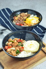 Ricebowl with egg and chicken filet served in bowl on the table