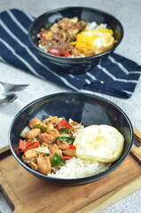 Ricebowl with egg and chicken filet served in bowl on the table