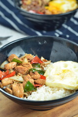 Ricebowl with egg and chicken filet served in bowl on the table