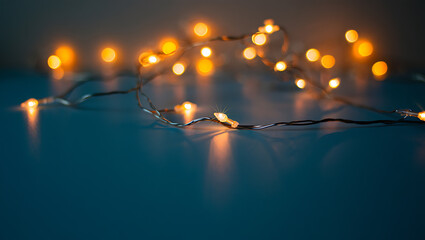 Warm glowing fairy lights on dark blue surface orange lights bokeh
