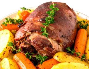 Succulent roasted leg of lamb with carrots potatoes and fresh thyme garnish.