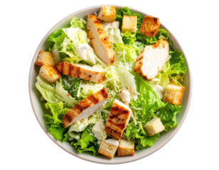 Fresh Caesar salad with grilled chicken slices crispy croutons and grated parmesan cheese in a bowl top view.