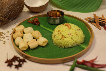 Lemon rice a popular south Indian dish, made by mixing cooked rice, lemon juice, turmeric, salt, curry leaves served with chips on banana leaf