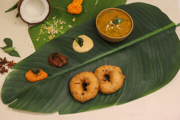 South indian thali food with sambhar and different types of chutney served on banana leaf