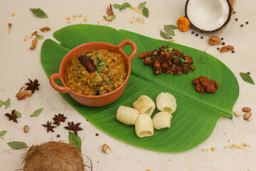 South indian thali food with sambhar and different types of chutney served on banana leaf
