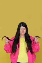 Adult Latina woman suffers from her long, damaged straight hair and split ends due to dryness and dehydration