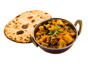 Spicy Indian vegetable curry in a traditional brass kadai with tandoori naan bread.