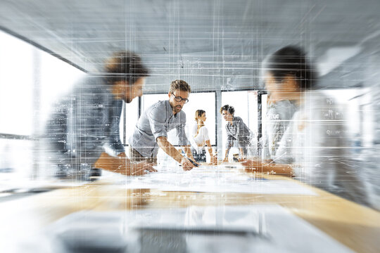 Business People Reviewing Documents with Digital Overlay in a Bright Office meeting team