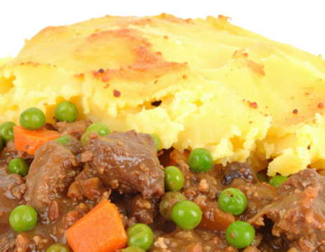 Hearty Shepherds Pie with a golden mashed potato crust featuring a rich stew of minced meat peas and carrots.