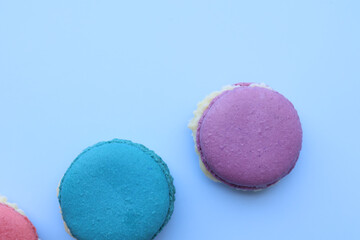 Closeup and Top view colorful macarons on a blue background. dessert cookies are both delightful and eye catching. with copy space