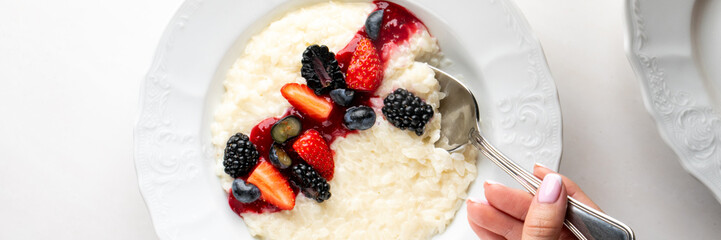 Delicate rice pudding adorned with vibrant berries cradles spring renewal, evoking Nowruz's...
