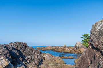 青空と岩礁が広がる海岸風景
