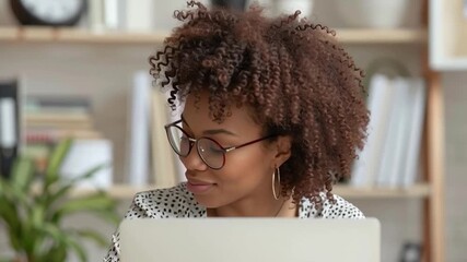 Pensive young woman working on laptop computer