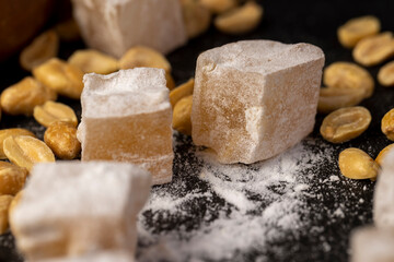 Turkish delight cubes and peanuts on a slate surface, close up