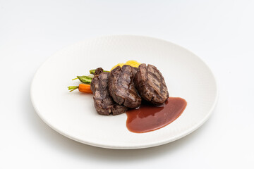 Juicy grilled filet medallions served with seasonal vegetables and sauce