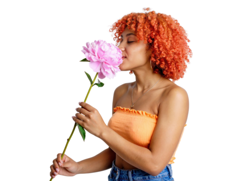 Serene young woman with vibrant orange curly hair smelling a large pink peony. - Powered by Adobe