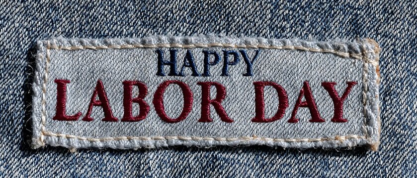 Happy labor day embroidered patch on denim fabric, celebrating American workers and national holiday.