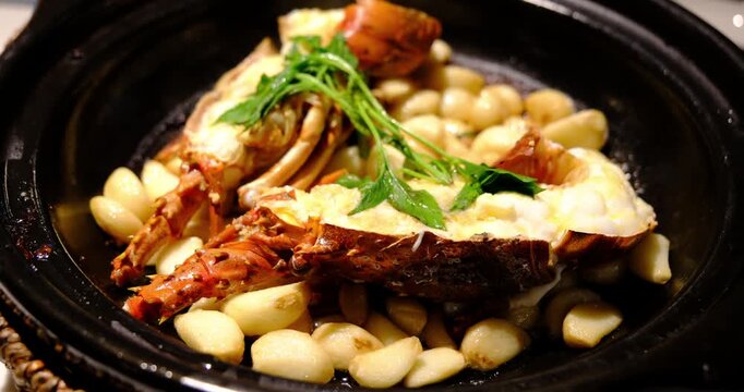 garlic lobster with garlic cloves in black pot