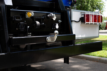 Truck rear view showing the towing hitch, electric connectors, and vehicle lighting system. The image highlights the metallic finish and modern design of the vehicle back section