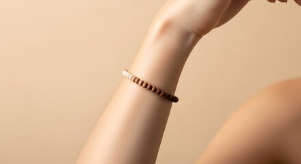 Woman's arm showcasing a stylish, multi-toned wooden beaded bracelet.
