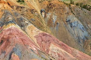 Background from sandy multi-colored mountain slope in Kyzyl-Chin valley at Altai republic, Russia. Altai Mars near village of Chagan-Uzun. Ground layers are colored by minerals and polymetallic ores