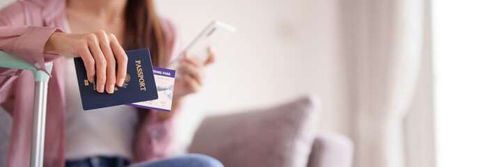 Asian adult female traveler holds passport boarding pass smartphone for international travel planning preparing seamless global journey adventure at home