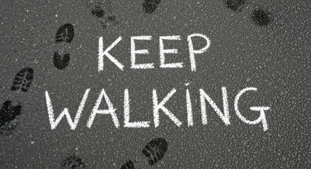 "Keep Walking" Chalk Text on Asphalt with Footprints