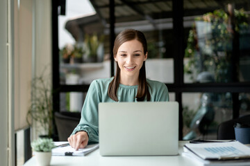 Young Businesswoman Working on Laptop Computer in Modern Office Caucasian Female Professional Smiling at Desk Doing Research Online Analyzing Data for Project Success