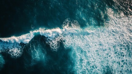 Obraz premium Aerial view of ocean waves displaying turquoise water and foamy texture
