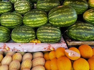 Abundant Display Of Fresh Ripe Watermelons And Several Varieties Of Melons At A Farmers Market Stall. Healthy Summer Fruit Harvest.