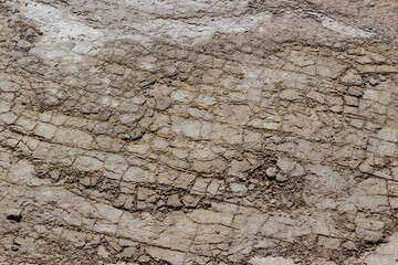 Gray dry soil or cracked clay ground texture background. The soil cracked into pieces from the drought