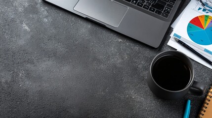 A laptop, coffee mug, and financial charts on a dark desk. Business productivity and data analysis at work.