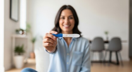 Happy woman holds up a positive pregnancy test, celebrating a new life.