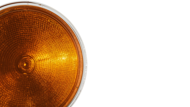 Closeup of amber traffic light lens on the transparent background highlighting circular pattern and texture