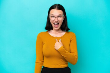Young caucasian woman isolated on blue background with surprise facial expression