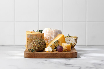 Wooden board with cheeses  and wine. Shropshire, langre, asiago, gorgonzola, shanklish cheese. Cheese plate.