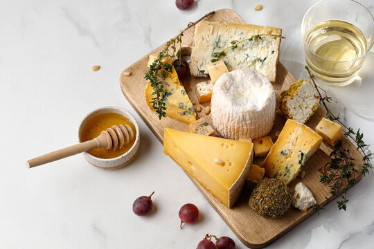 Different cheeses shropshire, langre, asiago, gorgonzola, shanklish cheese. Cheese plate with fruit, honey.
