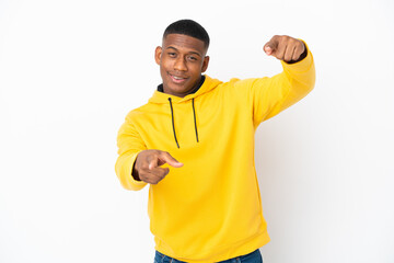 Naklejka premium Young latin man isolated on white background pointing front with happy expression