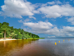 Fototapeta premium Panorama of blue sky with small cumulus clouds over beautiful Kisezers lake - one of the largest freshwater lakes with access in Baltic Sea. Riga, Latvia