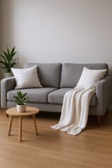Fototapeta premium Modern Living Room Interior with Grey Sofa, White Pillows, Cozy Blanket, and Small Wooden Side Table with Plant