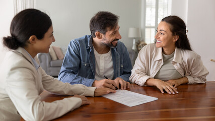 Married couple ready to sign contract, loan agreement, making profitable deal, buying or renting property during meeting with real estate agent. Acquisition of professional services and consultations