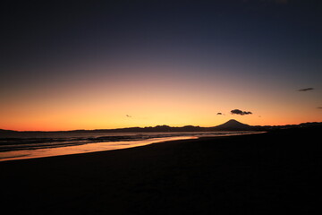 穏やかな波が打ち寄せる海岸、夕陽が染める鵠沼海岸　夕景