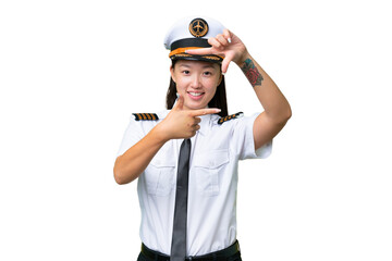 Airplane pilot Asian woman over isolated background focusing face. Framing symbol
