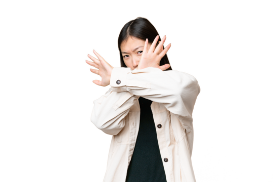 Young Asian woman over isolated chroma key background nervous stretching hands to the front