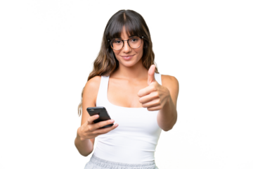 Young caucasian woman over isolated background using mobile phone while doing thumbs up