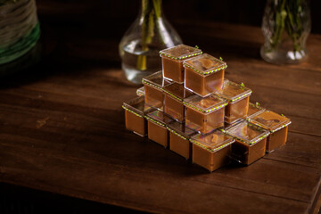 Gourmet caramel or doce de leite mousse desserts in individual cups stacked for a luxury party or wedding catering.