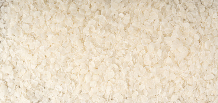 Raw flattened rice textured background. Dry rice flakes or poha pattern, Indian breakfast food