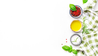 Food and cooking background, spices and herbs, top view. Rose and black pepper, fresh rosemary, basil, olive oil and sea salt on white table