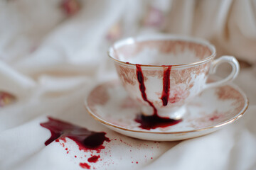 Vintage porcelain cup red liquid broken pattern spilled on white fabric mystery dramatic subtle tension murder mystery elegant close up, blood, criminal